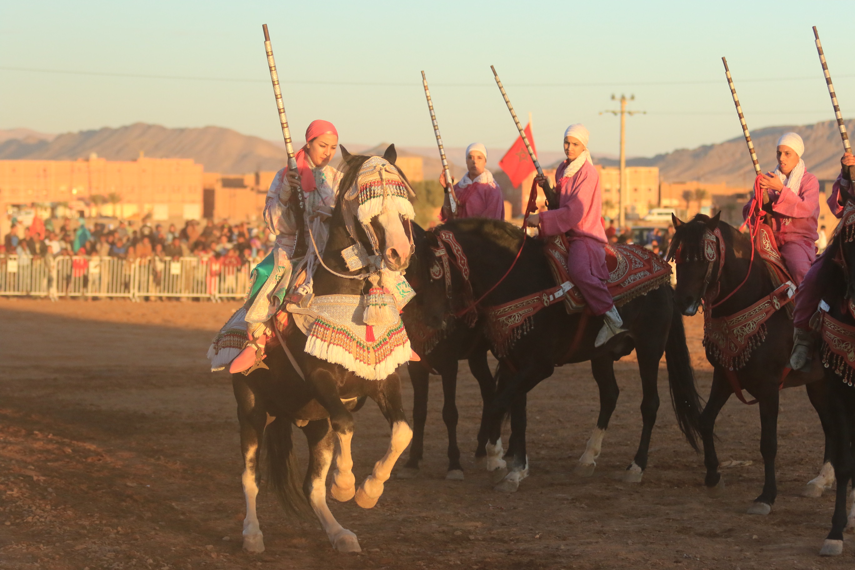 One woman on horseback appears in from of two others and she holds what appears to be a lance with one hand while her horse rears on its hind legs.