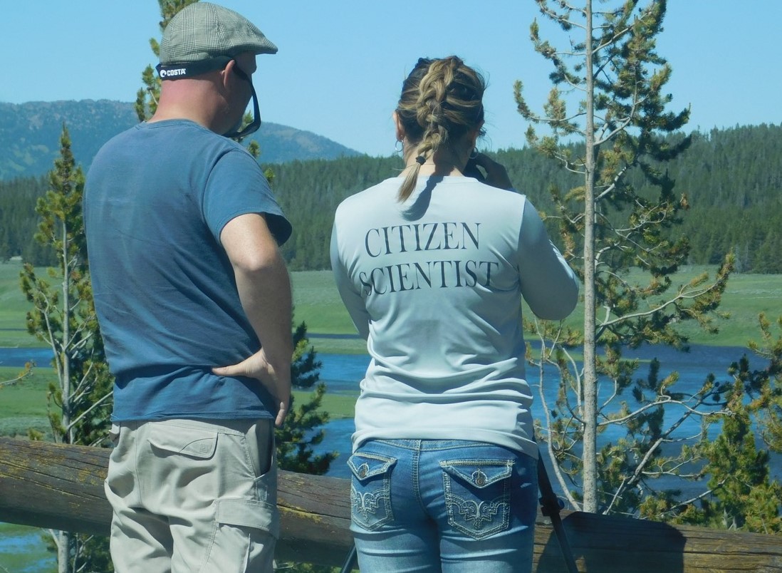 Photograph of two people standing at one of the Hayden Valley Overlooks in Yellowstone National Park.