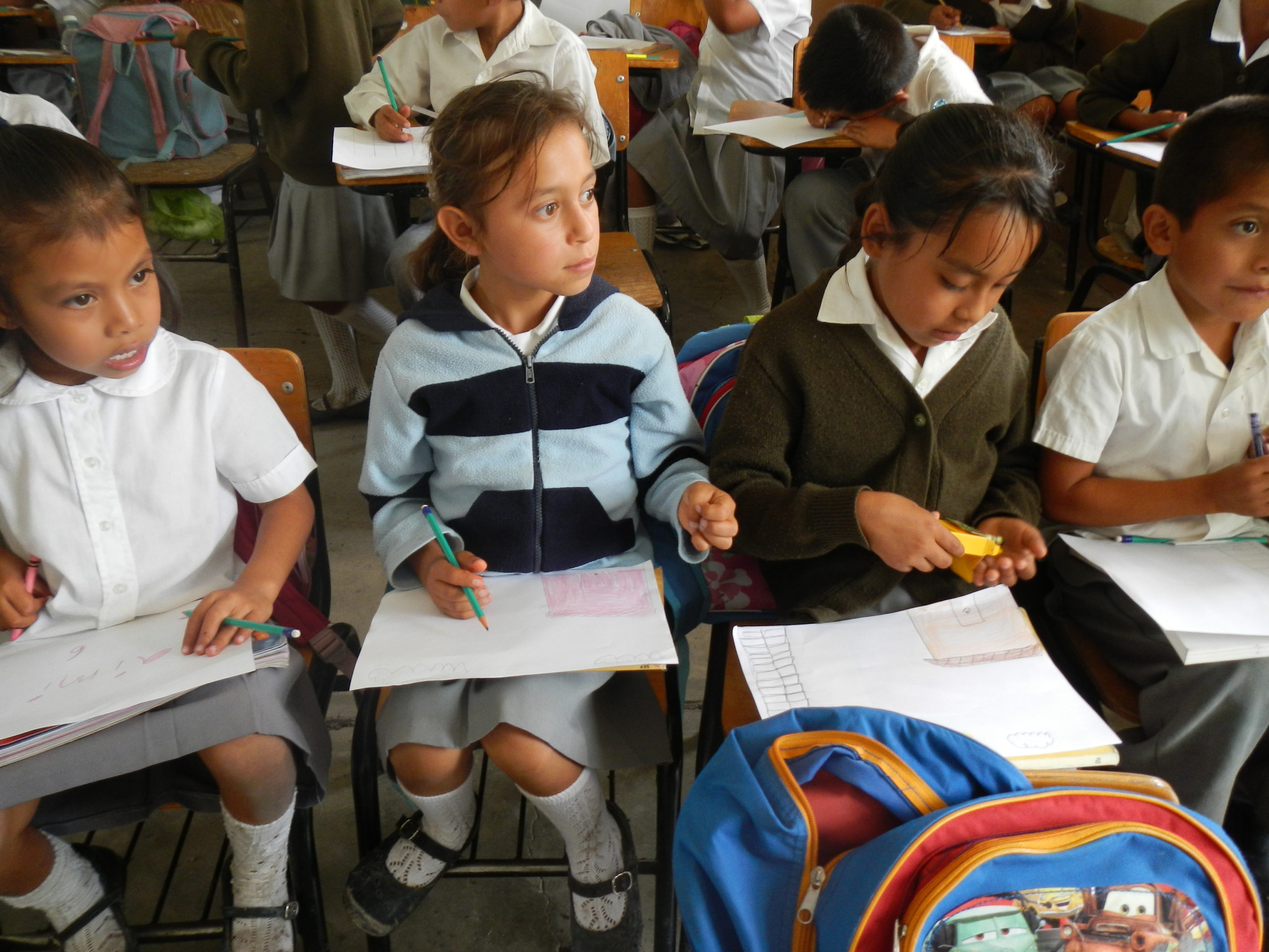 A color photograph of elementary-aged students in a classroom in Puebla, Mexico.