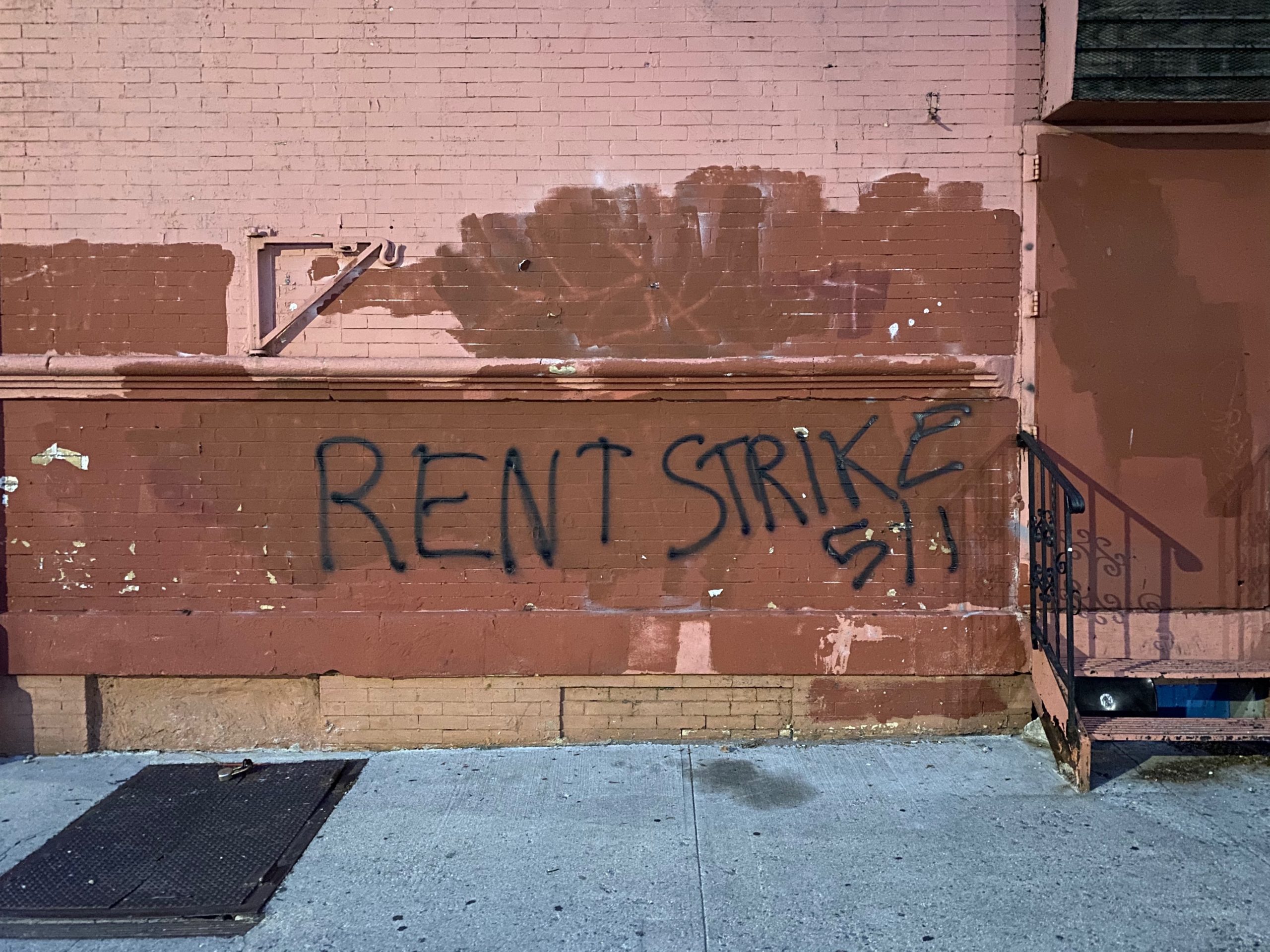 A picture of rent strike graffiti on building.