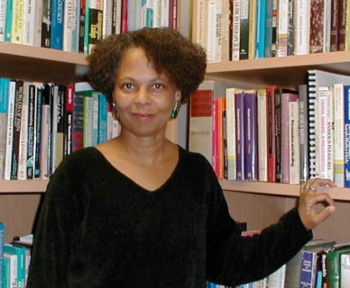 Picture of a Black woman in front of a bookcase