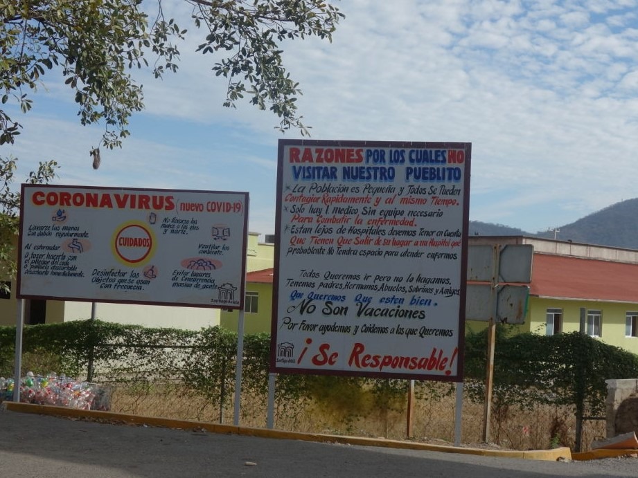 A picture of two signs that provide information about COVID-19 in a community.